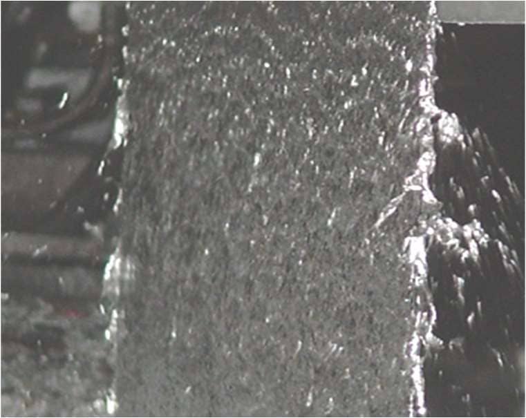 Splashing condition at the air knives showing early stage separation of liquid zinc from the strip surface