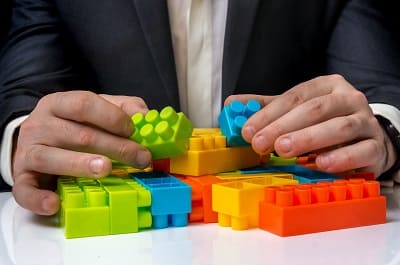Business professional arranging building blocks representing corporate restructuring and turnaround