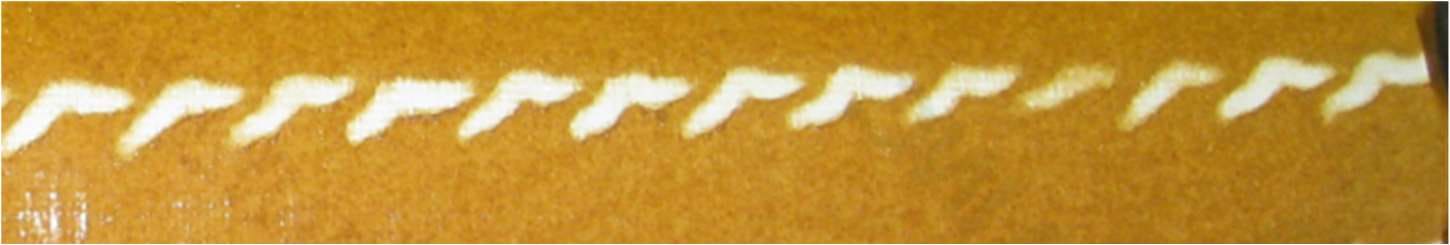Test paper wrapped around a work roll showing spray impact marks, with one deteriorated spray impact visible