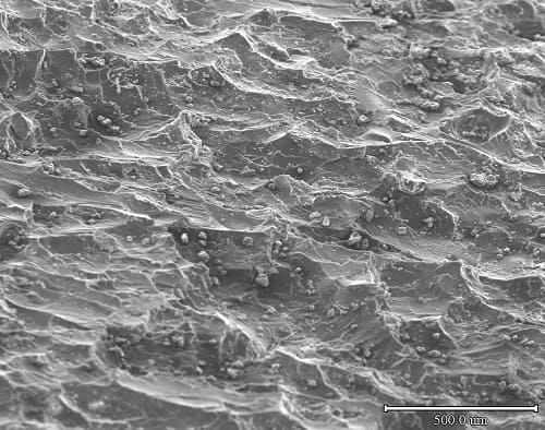 Magnified image of plastic mandrel sleeve surface showing rough pocket topography at 500 micron scale