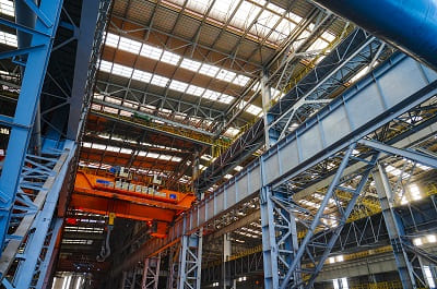 Overhead gantry crane and structural steelwork inside a modern steel plant