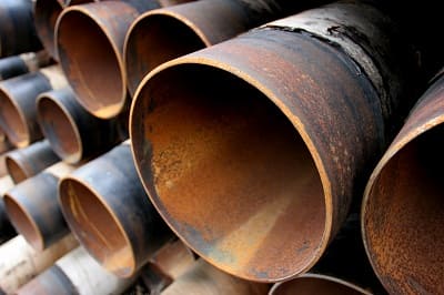 Stack of weathered steel pipes showing rust and oxidation on exterior surfaces
